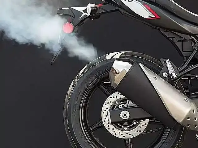 Moto roja que necesita puesta a punto por que tira humo por el mofle o exosto